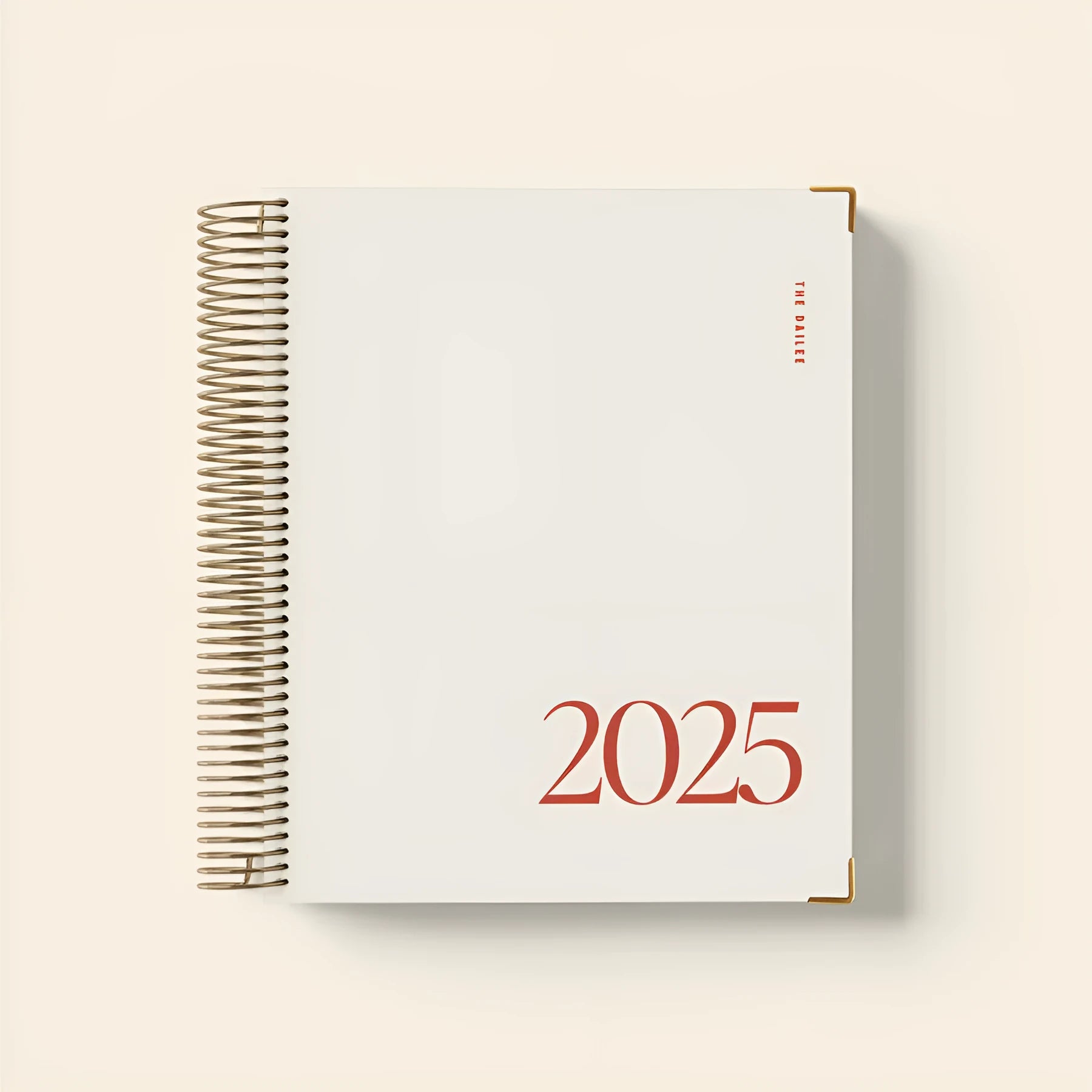 Cherry red spiral coil-bound daily schedule notebook lying open on a table.
