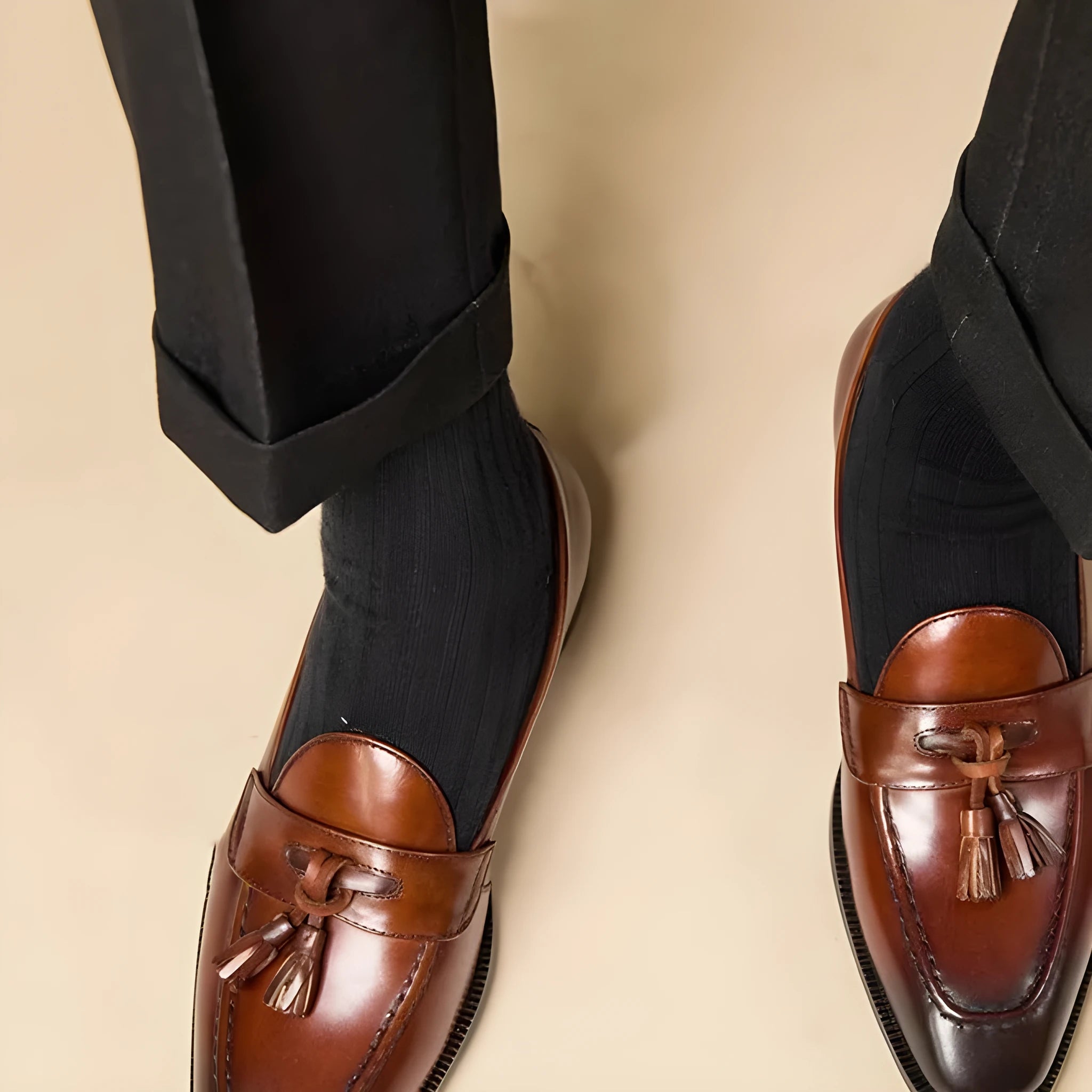 Men's genuine leather tassel loafers in black and brown colours showing polished uppers and rubber soles