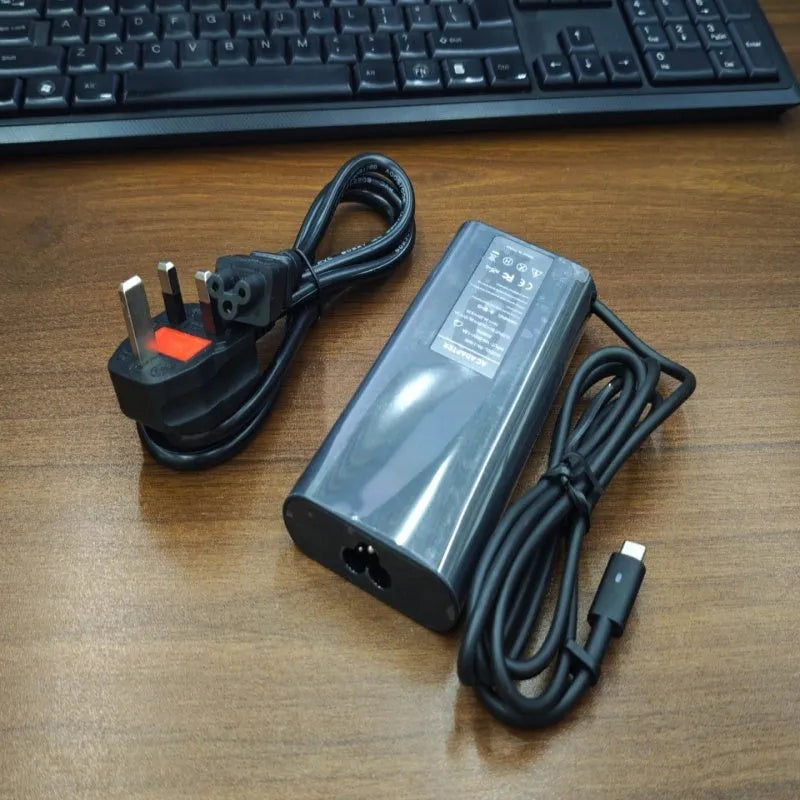Black 65W Type-C laptop power adapter with multiple international plug heads on a white background.
