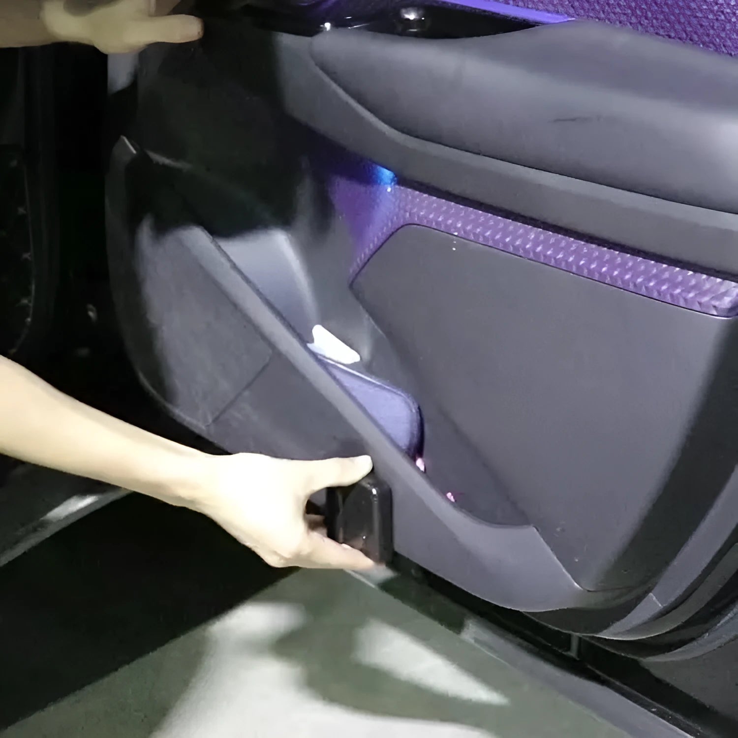 Compact black car interior projection lamp with universal fit, shown next to three AA batteries for scale.