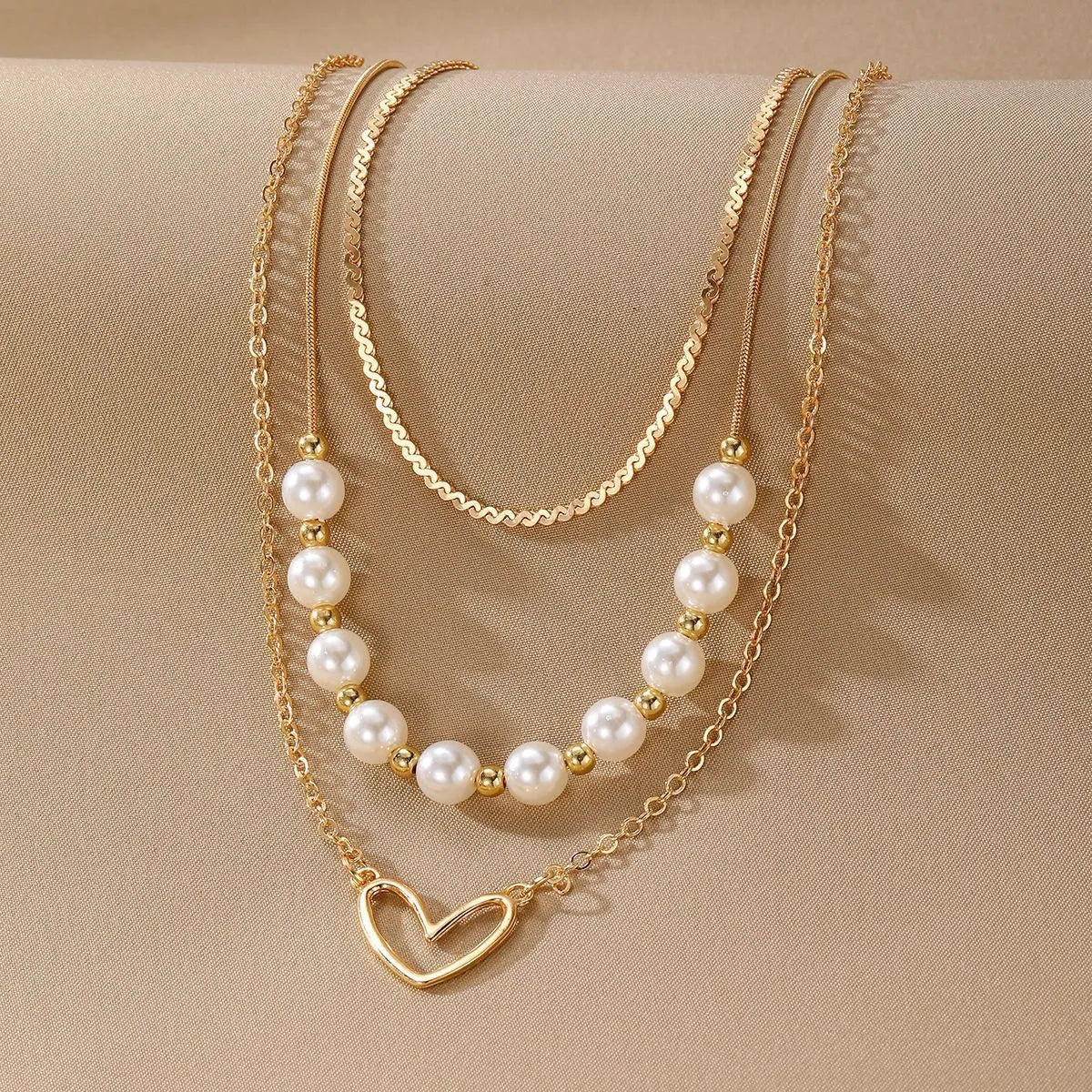 Vintage gold necklace with heart pendant and pearl details on chain