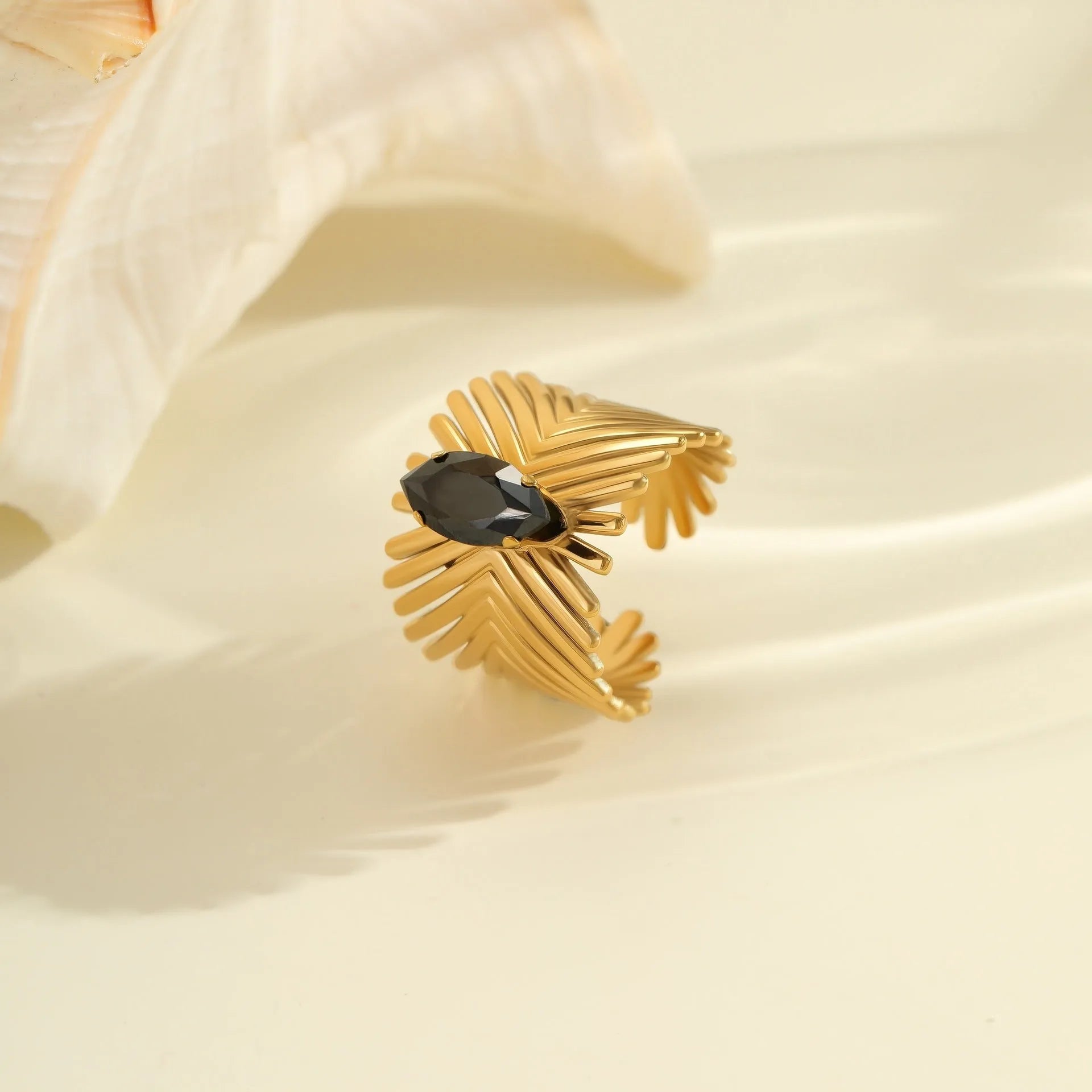 Geometric open-mouth stainless steel ring for women with inlaid zircon stones on a grey background.