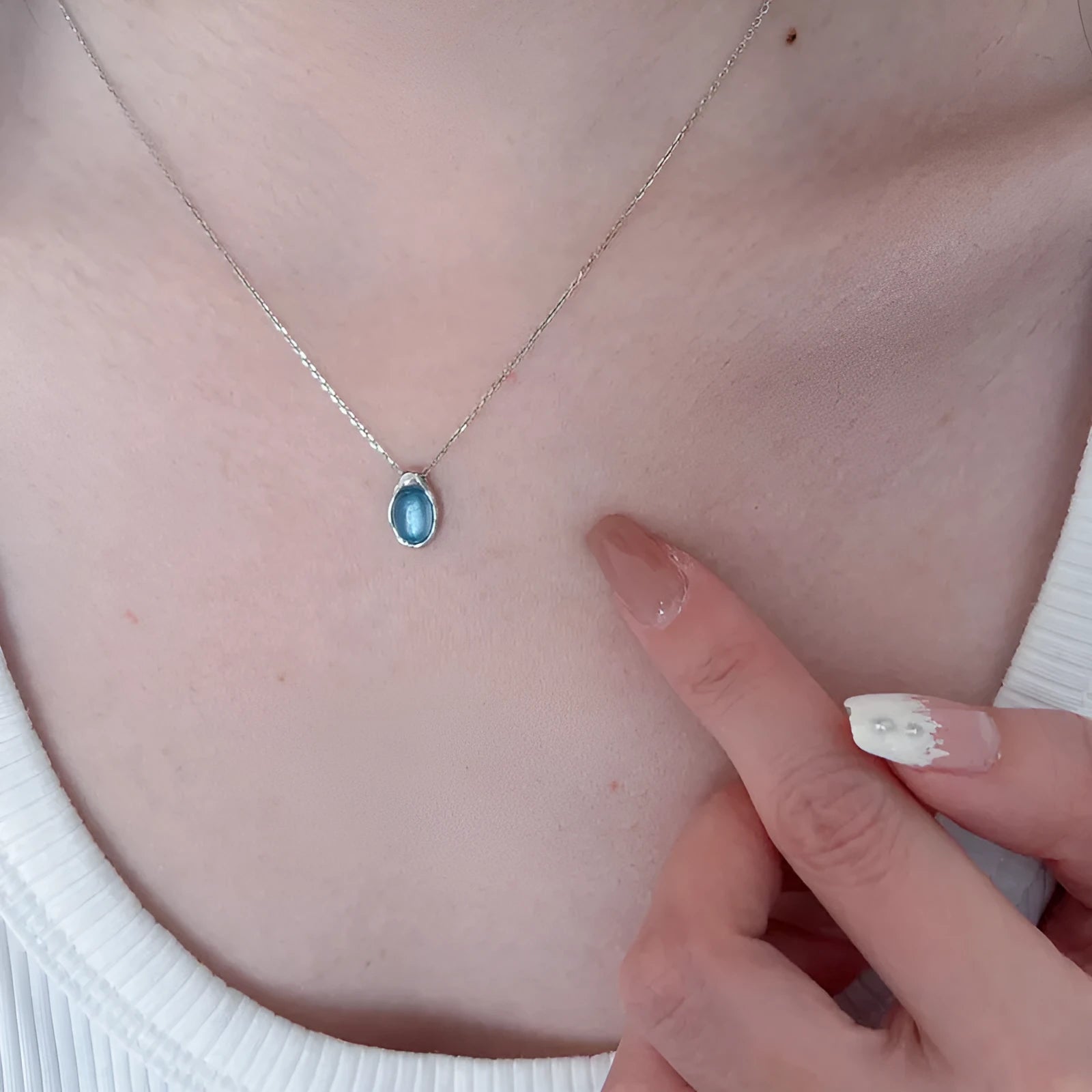Navy blue water drop pendant necklace with adjustable chain on neutral background