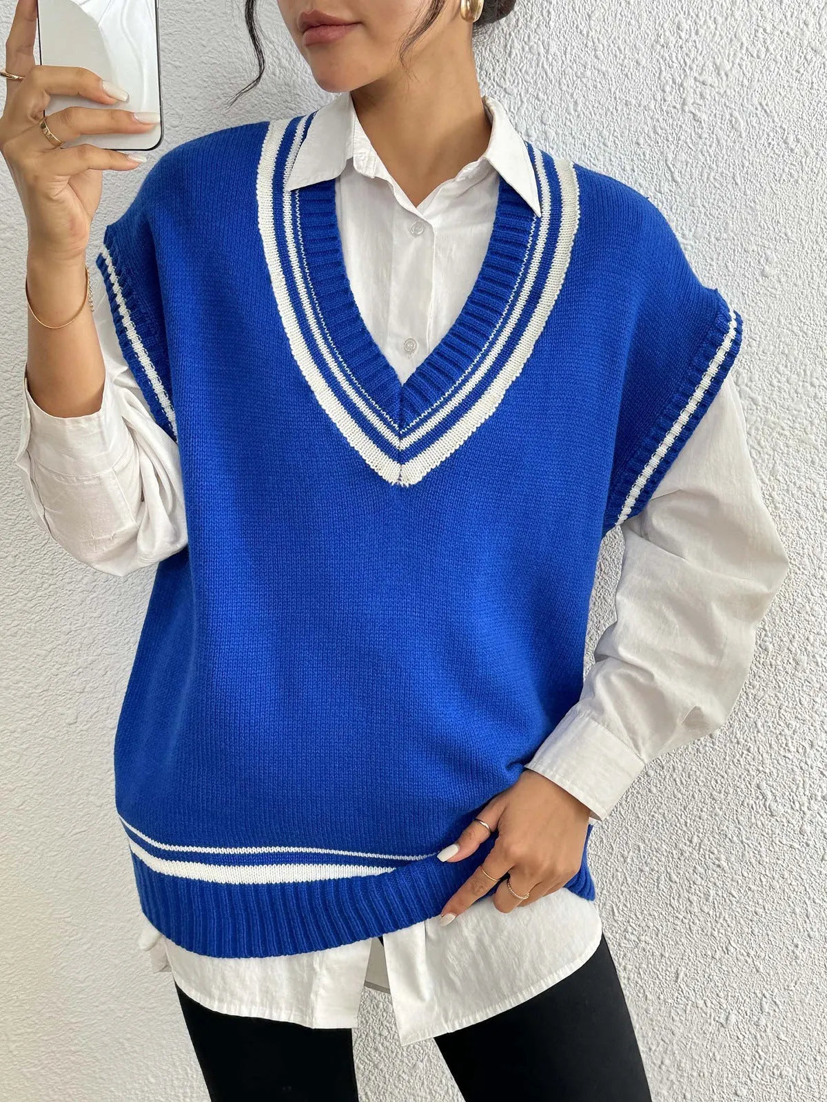 Blue loose-fit women's acrylic blend vest sweater on a hanger, college style.