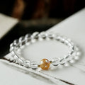 Geometric obsidian white crystal bracelet with black agate beads and gold dragon charm on wrist