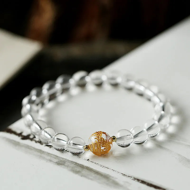 Geometric obsidian white crystal bracelet with black agate beads and gold dragon charm on wrist