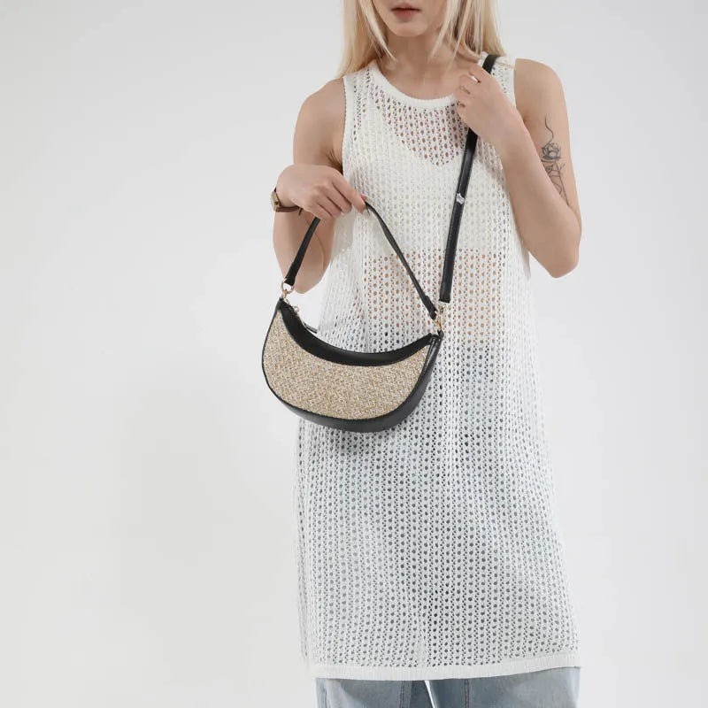 Woven straw dumpling-shaped crossbody bag with adjustable shoulder strap and internal organisational compartments