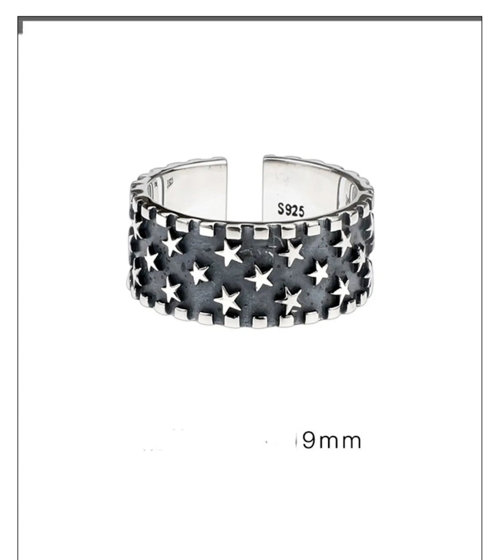 Adjustable opening sterling silver ring with a geometric pattern of several five-pointed stars.