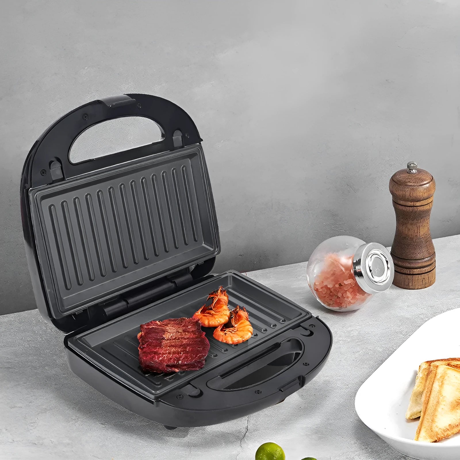 Black electric sandwich pan with double-sided heating, non-stick coating, and brushed stainless steel top cover