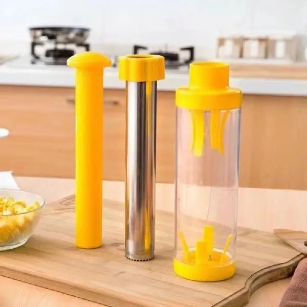 Yellow cylindrical corn stripper kitchen tool with stainless steel mechanism on a wooden surface.
