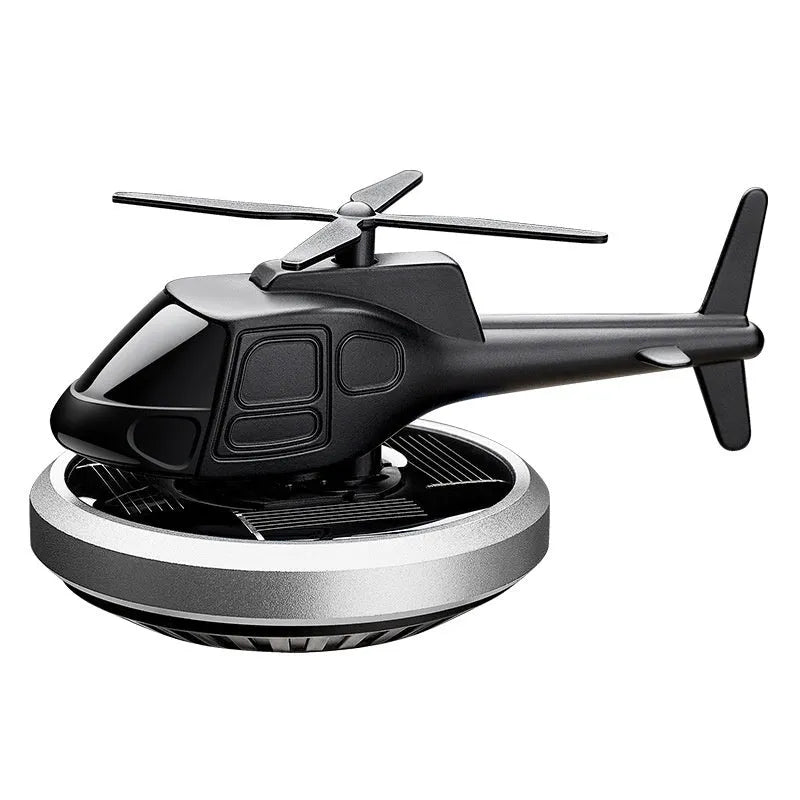 Silver metal solar helicopter car perfume ornament with rotating blades on car dashboard