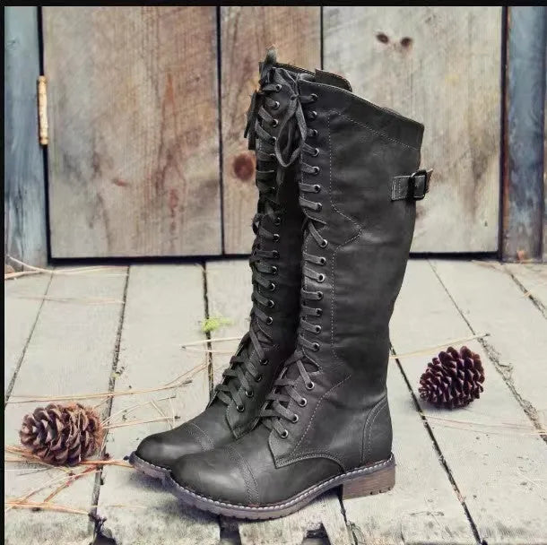 Women's black high leg boots with a chunky low heel and round toe on a solid background.