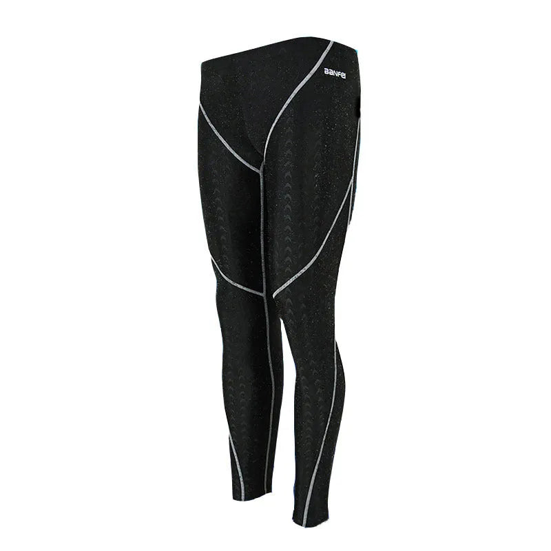 Men's black and grey line nylon cropped swimming trunks laid flat.