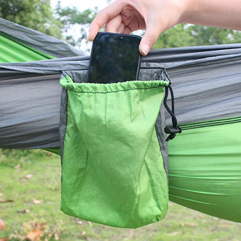 Blue parachute nylon camping hammock hung between two trees showing its full 270 cm length.