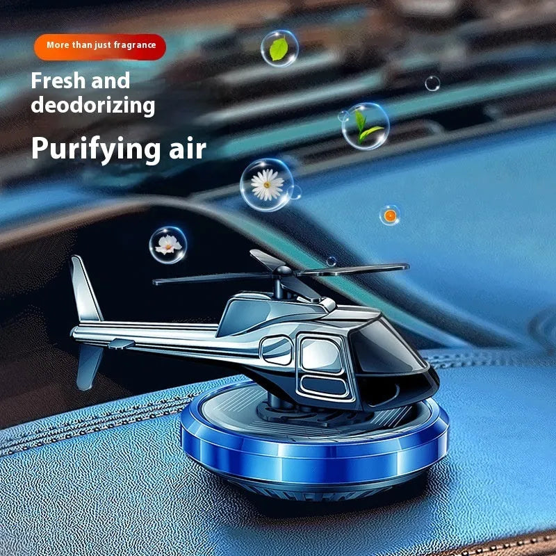 Silver metal solar helicopter car perfume ornament with rotating blades on car dashboard