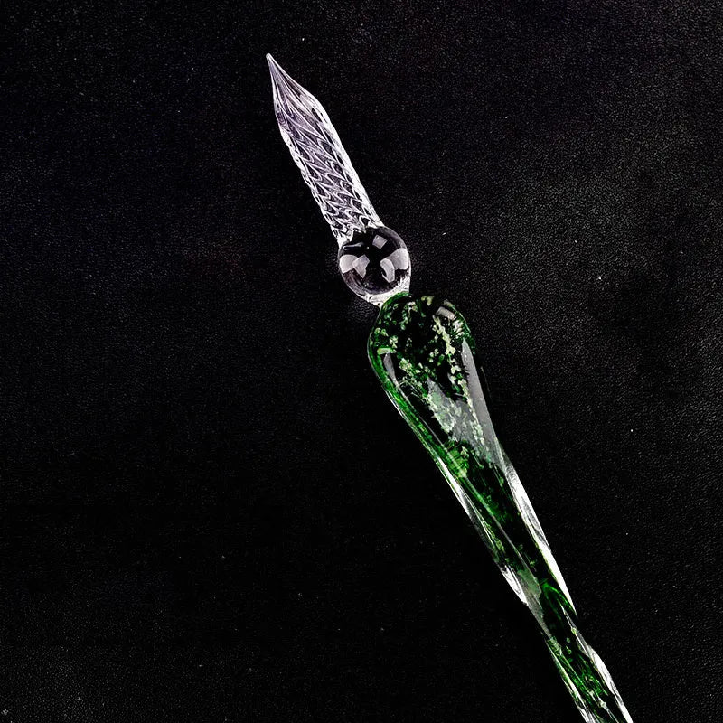 Crystal glass dip pen with transparent body and coloured ink, on a white background