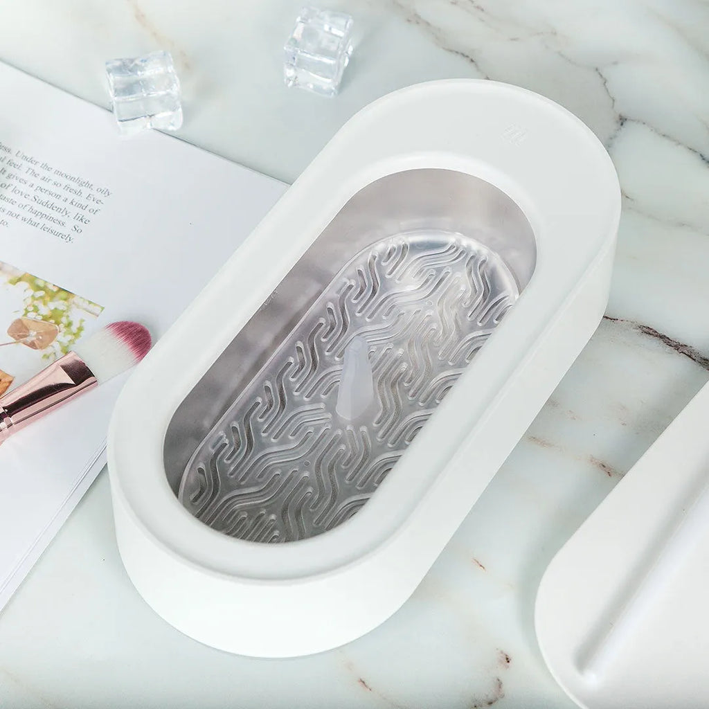 White portable ultrasonic cleaning machine with stainless steel tank for jewellery and glasses.