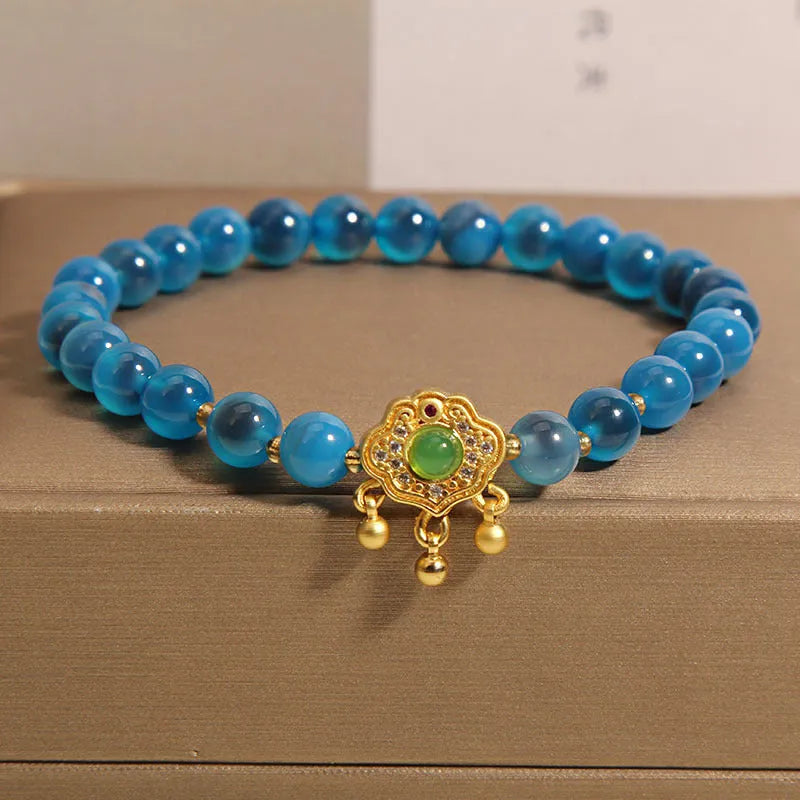 Blue sugar heart agate and jade safety lock pendant on a women's crystal bracelet with alloy inlay.