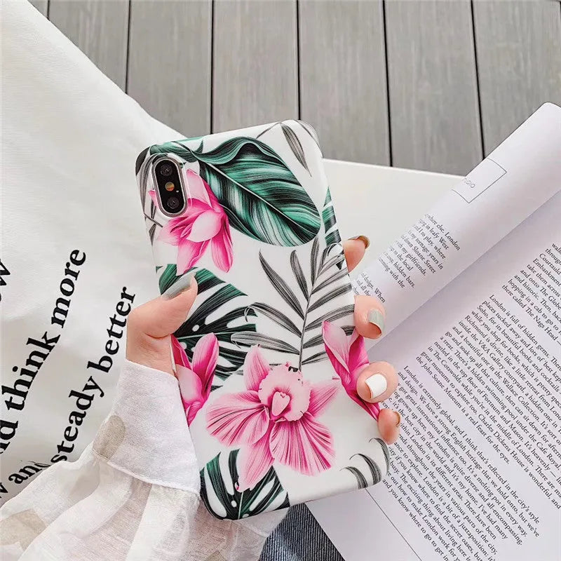 Pink floral patterned TPU back cover case for iPhone on a table.