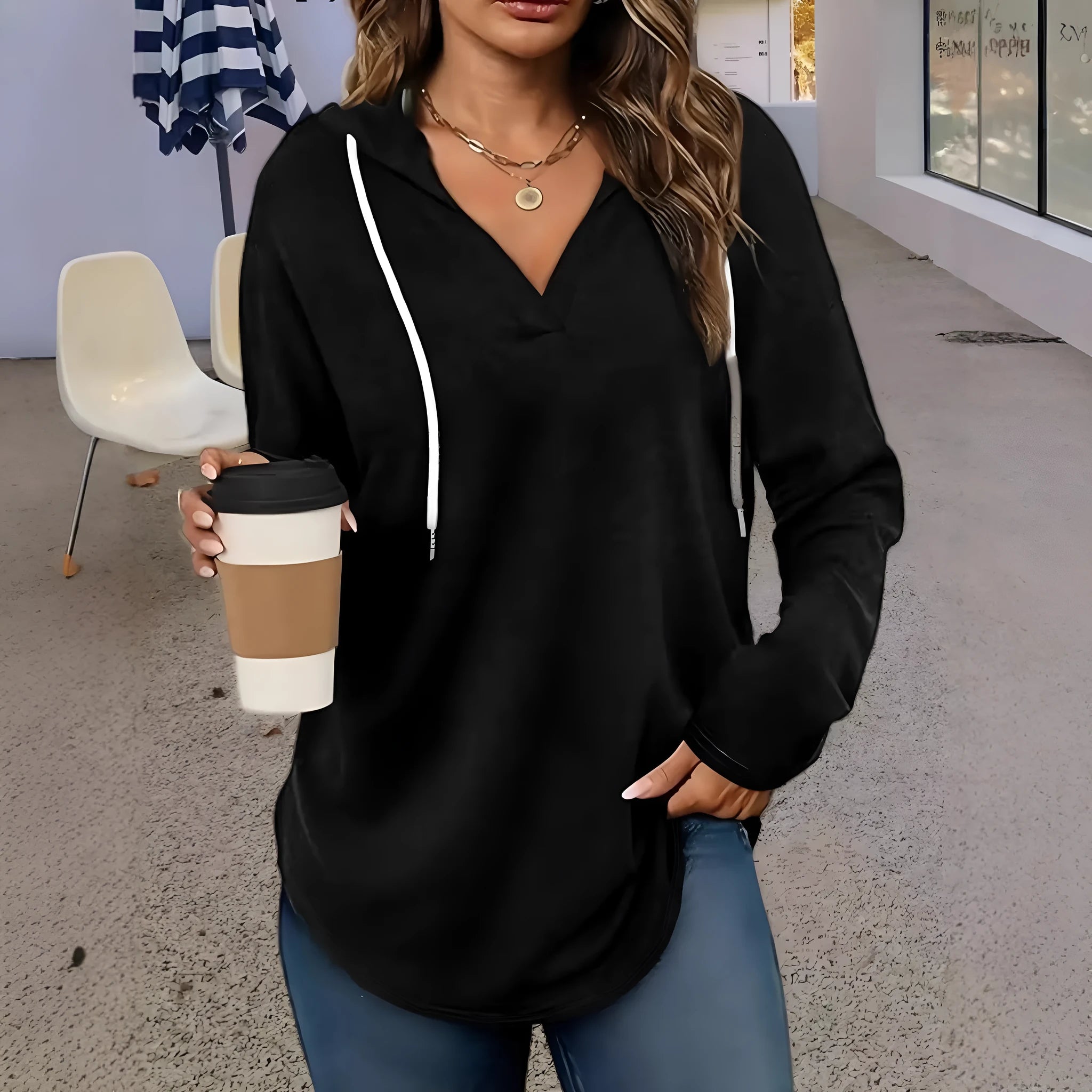 Women's red V-neck sweatshirt with hood and long sleeves showing loose fit design