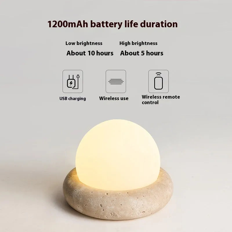 Cream coloured bedside night light with remote control on wooden table