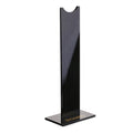Black detachable head-mounted gaming headset stand with a silicone base on a wooden desk.