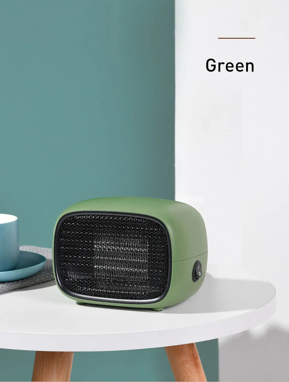 Compact green mini ceramic heater with metal mesh grille on a desk