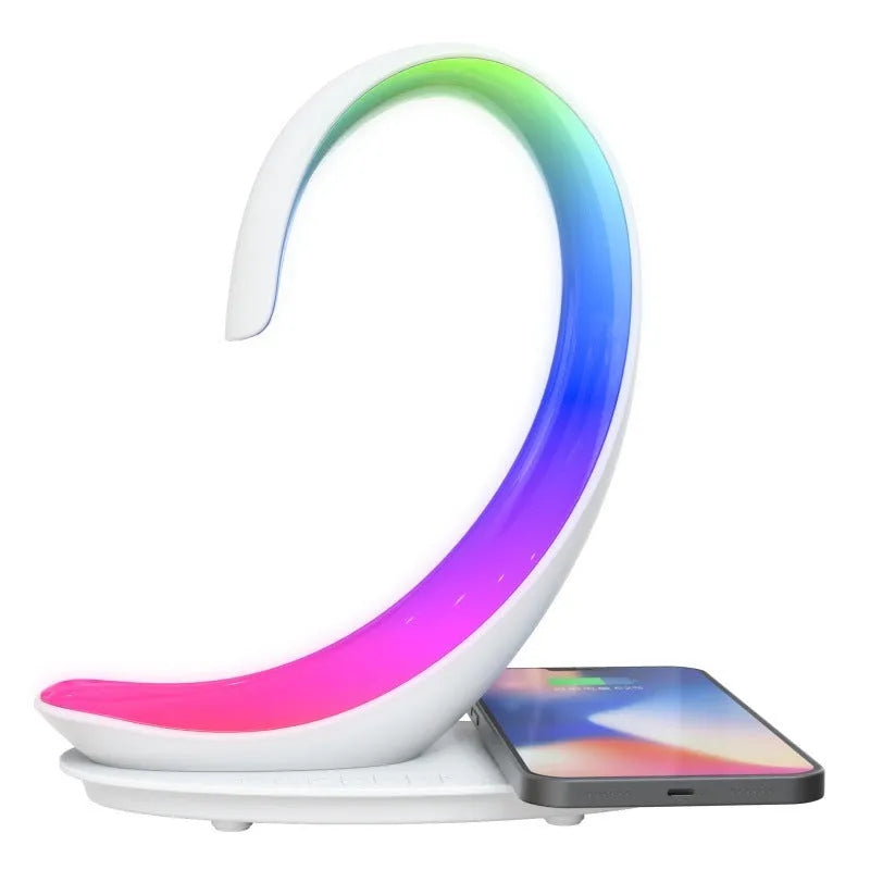 White swan-shaped desk lamp with wireless charging base and Bluetooth speaker emitting colourful light.