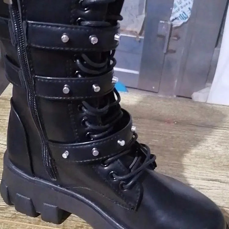 A pair of black mid-calf women's boots with metal buckle details and a side zipper on a white background.