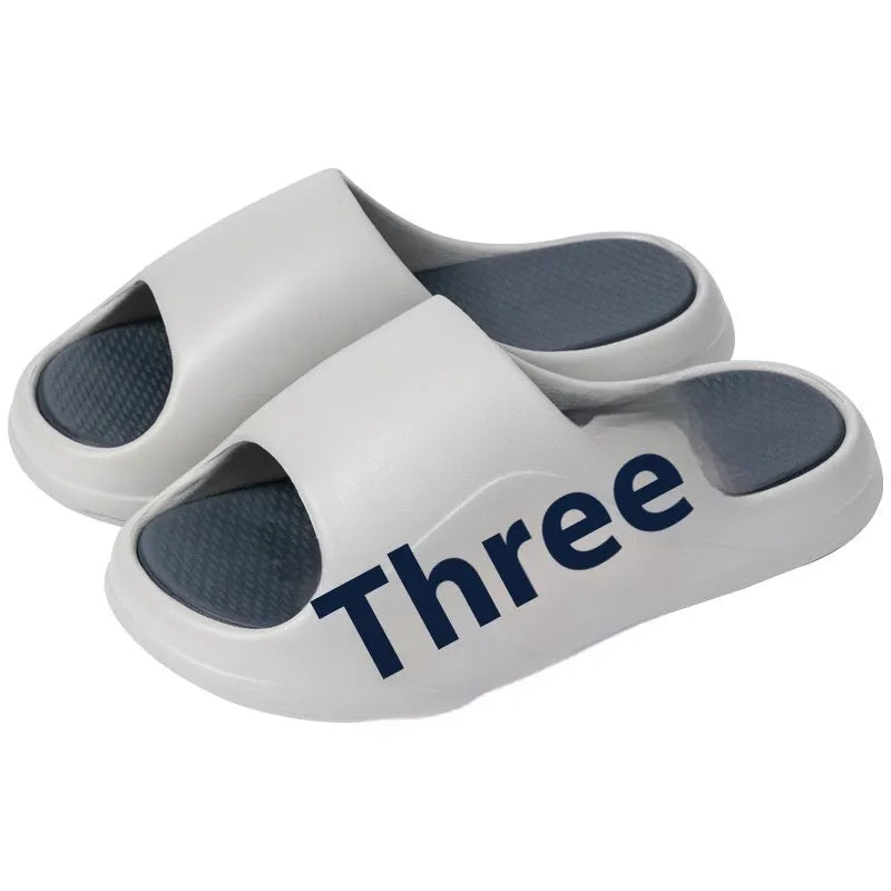 Men's and women's brown EVA platform slippers with a letter detail on the upper, shown on a white background.
