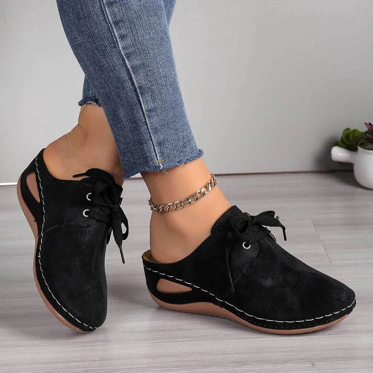 Women's black lace-up wedge slippers with suede upper and hollow-out design on a rubber sole.
