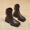 Black platform Martin ankle boots for women with a square toe and back zipper on a white background.