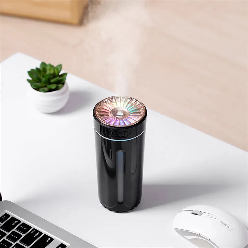 Black portable car humidifier with colourful LED lights showing mist output, placed in vehicle cup holder