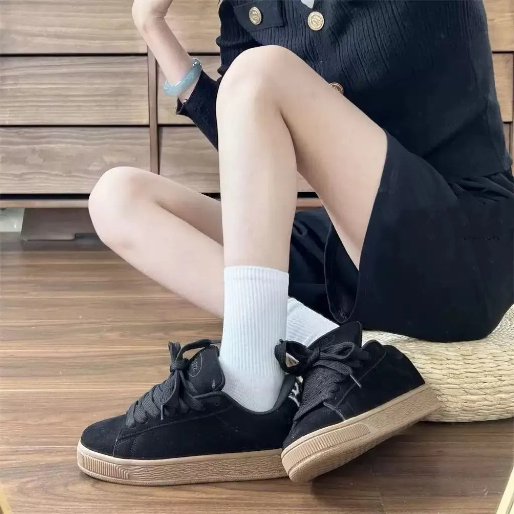 Black retro low-top sneakers for men and women on a white background, showing round toe and lace-up design.
