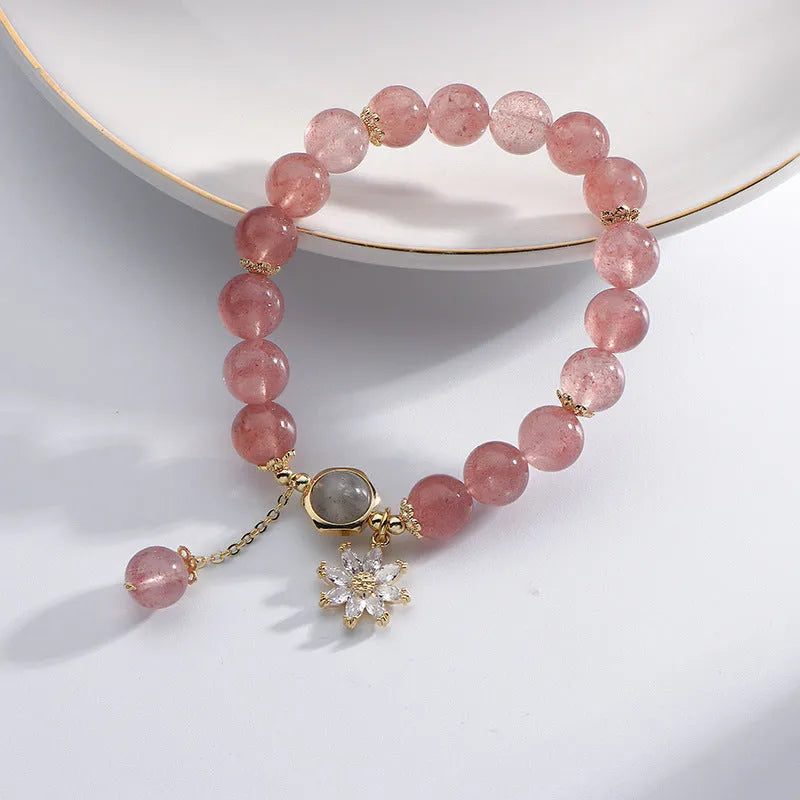 Strawberry quartz Mori style bracelet with electroplated floral details on a white background