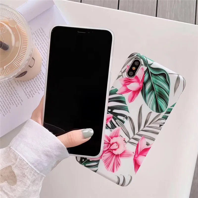 Pink floral patterned TPU back cover case for iPhone on a table.