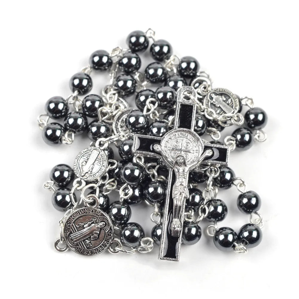 Black rosary necklace with hematite beads and zinc alloy cross on plain background