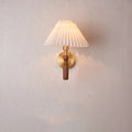 Retro wooden wall lamp with fabric shade in walnut finish mounted beside a bed.
