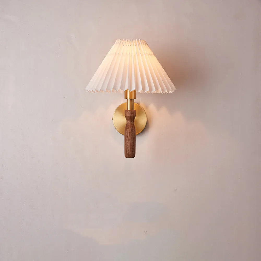 Retro wooden wall lamp with fabric shade in walnut finish mounted beside a bed.