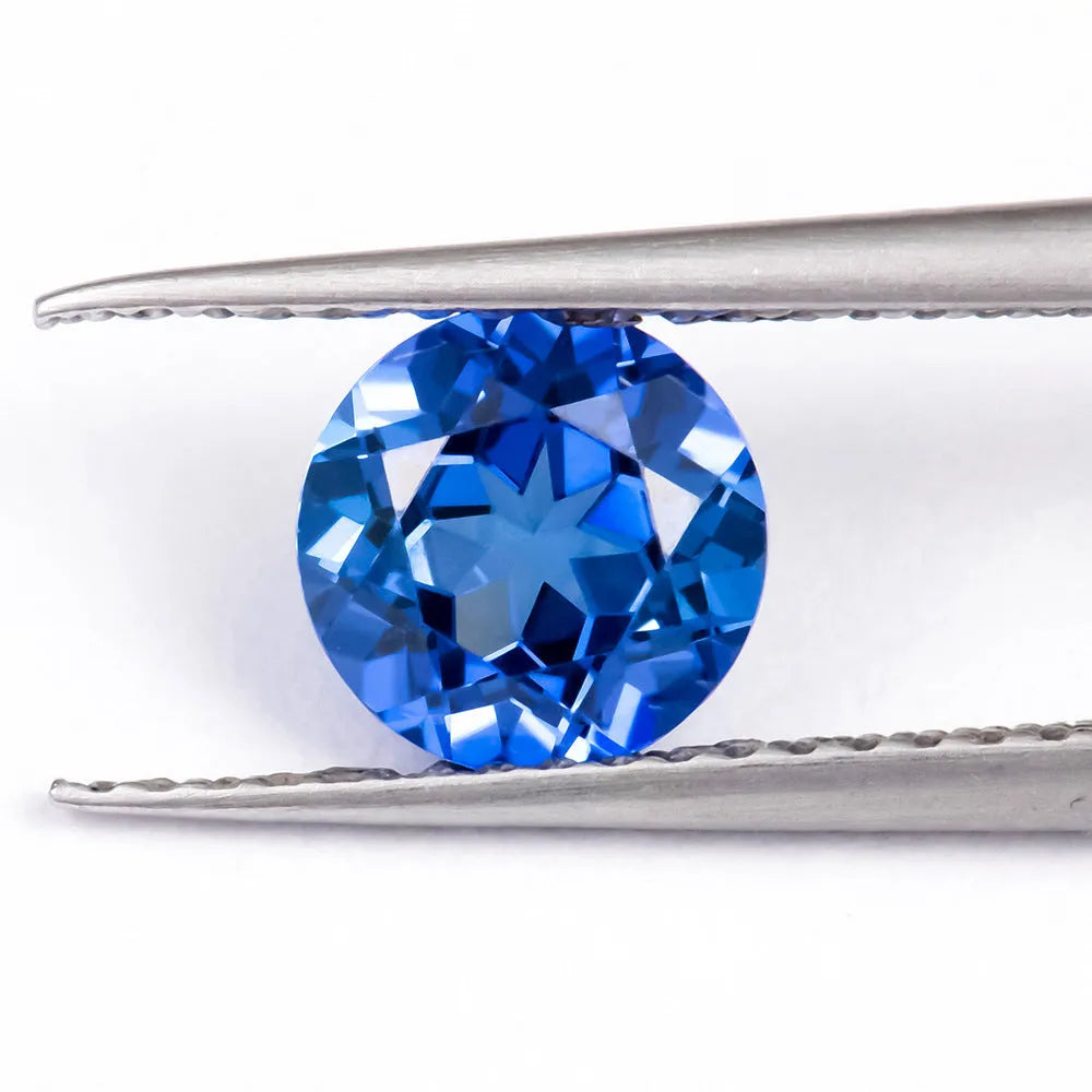 Royal Blue loose gemstone showing round and heart shapes on a grey background