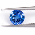 Royal Blue loose gemstone showing round and heart shapes on a grey background