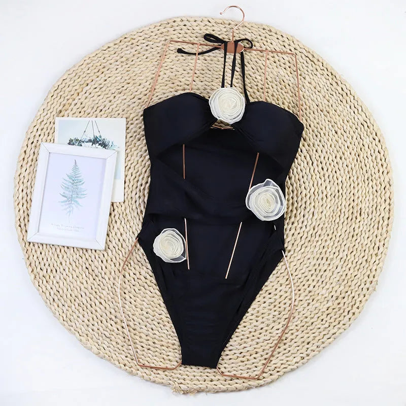 Women's black and blue striped one-piece swimsuit with 3D flower design on the front.
