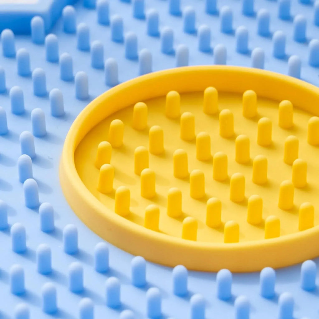 Flower-shaped silicone pet lick mat in assorted colours with suction cups on the base.