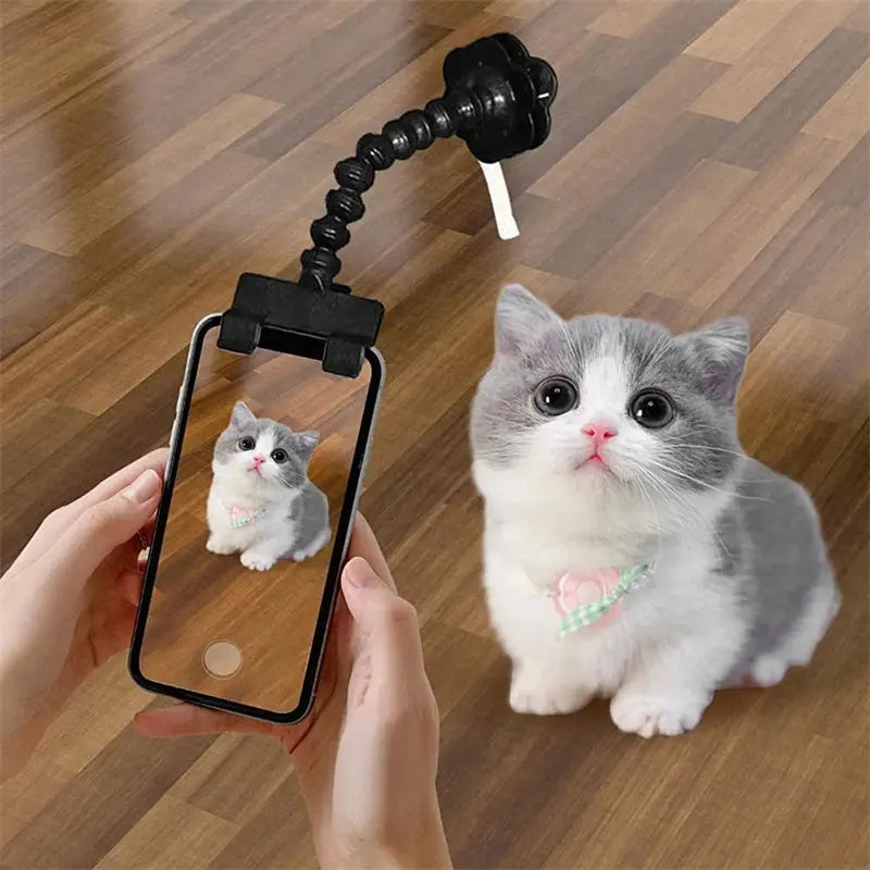 Black pet photography clip with rotating treat holder attached to mobile phone