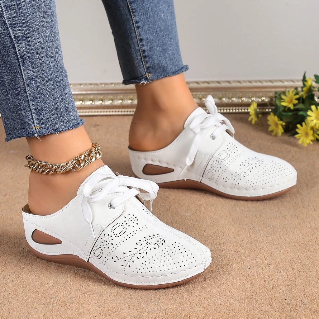 Women's black lace-up wedge slippers with suede upper and hollow-out design on a rubber sole.