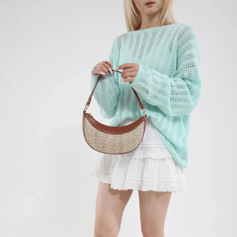 Woven straw dumpling-shaped crossbody bag with adjustable shoulder strap and internal organisational compartments