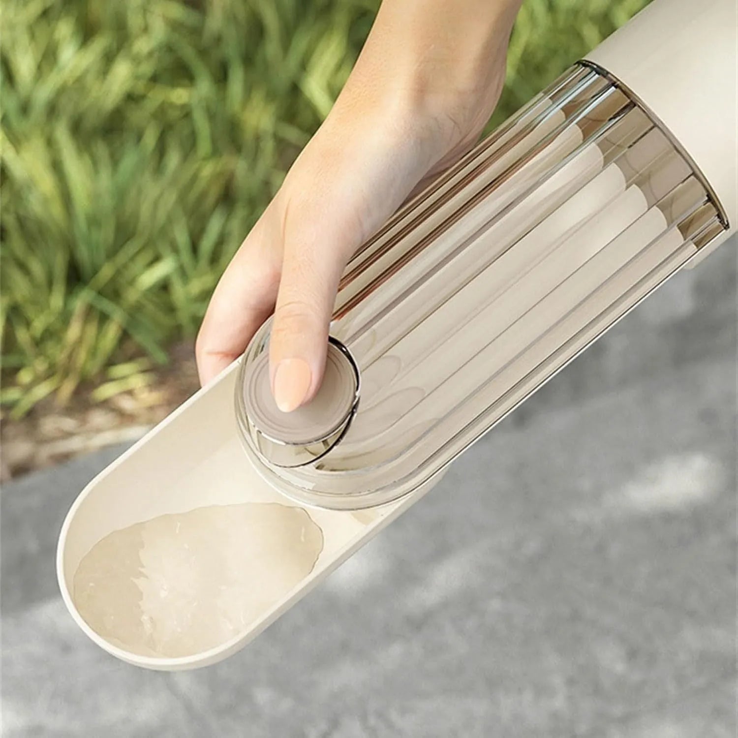 Beige foldable dog water bottle with integrated food container, shown with press-button tray.