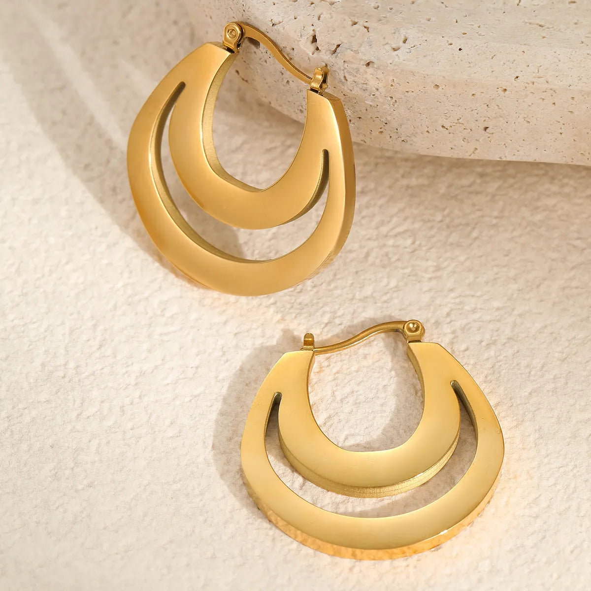 Geometric French earrings with gold plating and round ring elements on stainless steel