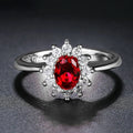 Women's floral ring with blue moissanite stone on electroplated copper band, shown in green, sapphire blue, and pomegranate red colour options.