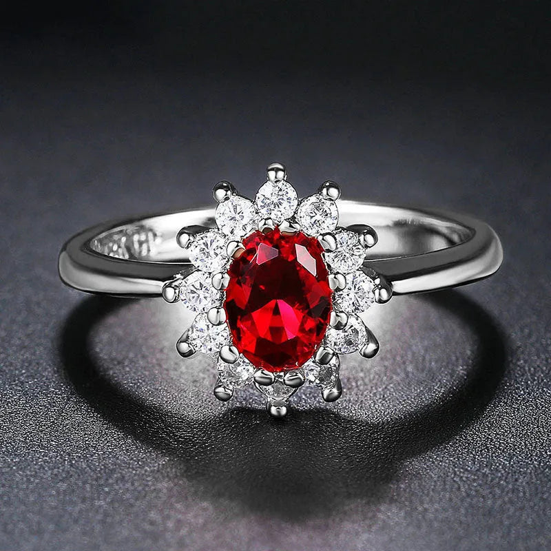 Women's floral ring with blue moissanite stone on electroplated copper band, shown in green, sapphire blue, and pomegranate red colour options.